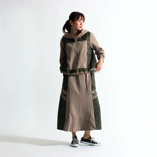 Soyombo（ソヨンボ）のキルティング切り替えフーディーとスカートのセットアップを着用した女性。ベージュとカーキの落ち着いた配色が都会的な、リラックス感のある大人ミリタリースタイル。