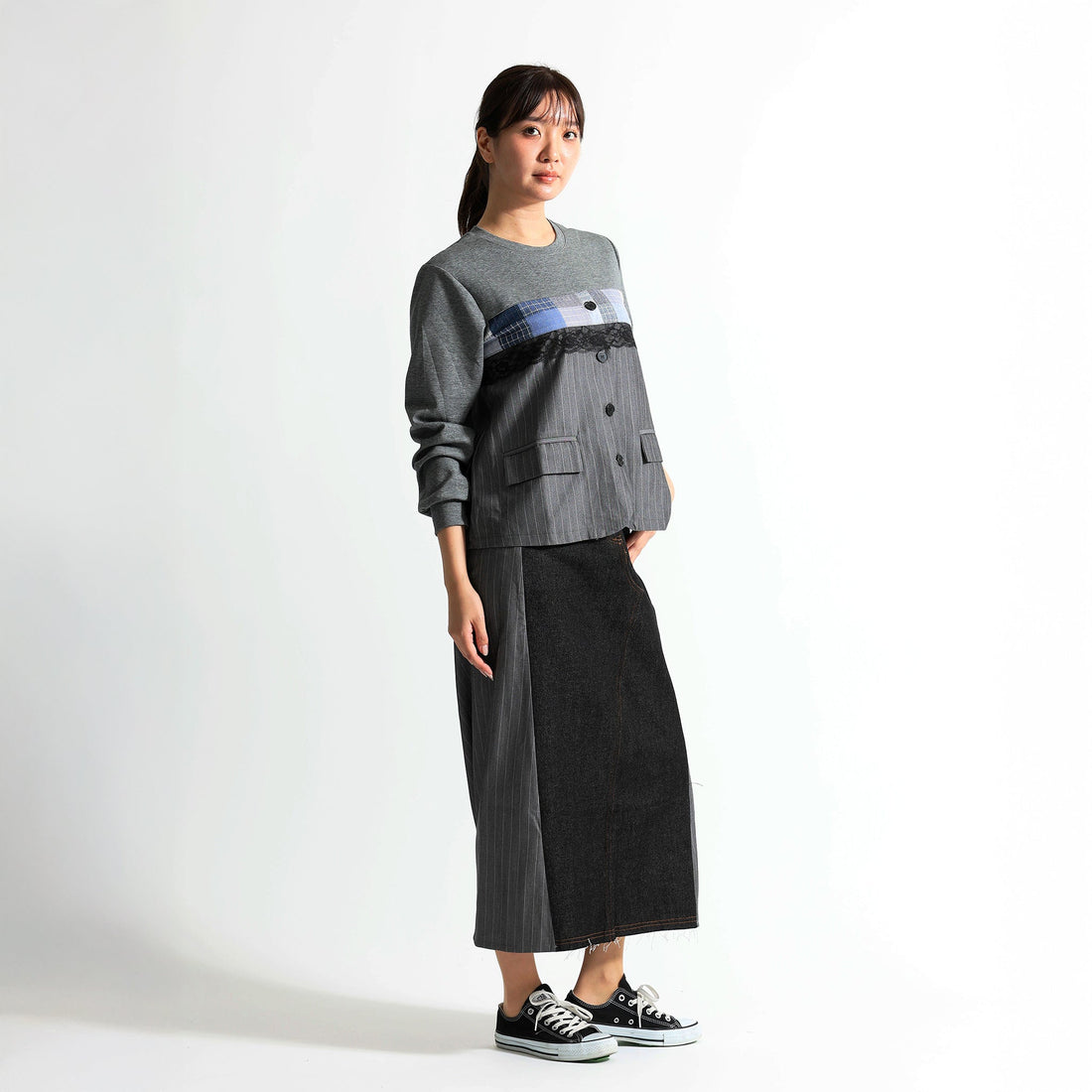 Soyombo（ソヨンボ）のストライプ切り替えプルオーバーとデニムタイトスカートを着用した女性。パッチワークデザインが目を惹く、大人の洗練されたカジュアルスタイル。